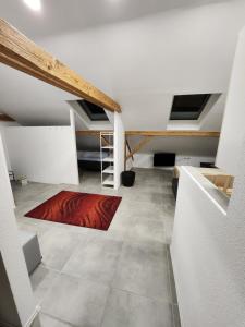 a attic room with a red rug on the floor at Bone ma in Bad Saulgau