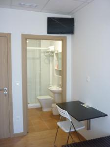 a bathroom with a black table and a toilet at Pensión-Albergue Puente Ribeira in Sarria