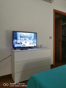 Elle comprend une télévision à écran plat installée au-dessus d'une commode. dans l'établissement Dimora OltreMare, à Bari