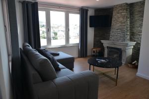 a living room with a couch and a fireplace at Marvão Serra & Mar in Seia