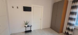 um quarto com uma televisão e uma porta com uma planta em B and B da Magna Cichina em Collegno