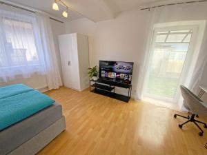 a bedroom with a bed and a flat screen tv at Jacky & Daniel's Apartments Top 1 in Sankt Pölten