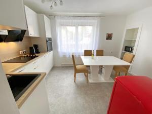 cocina blanca con mesa blanca y sillas en Jacky & Daniel's Apartments Top 1 en Sankt Pölten