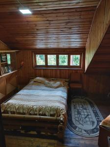 1 dormitorio con 1 cama en una cabaña de madera en WoodHouse, en Dilijan