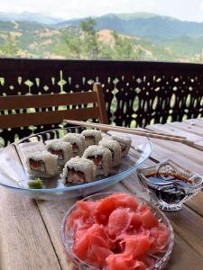 una mesa con dos platos de sushi y un tazón de tomates en WoodHouse, en Dilijan