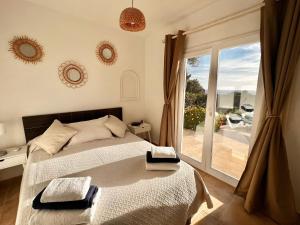 a bedroom with a bed and a large window at Villa Joanna in Son Bou