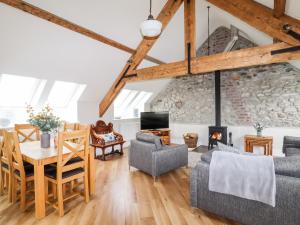 a living room with a table and chairs and a fireplace at Yr Hen Festri in Llanddeiniolen