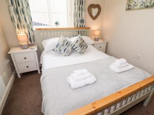 a bedroom with a bed with towels on it at Yr Hen Festri in Llanddeiniolen
