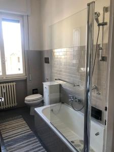 La salle de bains blanche est pourvue d'une baignoire et de toilettes. dans l'établissement Holly's House apartment, à Alzano Lombardo