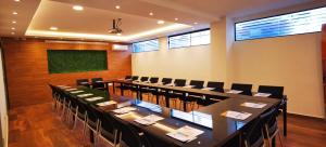 una sala de conferencias con una mesa larga y sillas en Premium Suites Deluxe Aparthotel Equipetrol en Santa Cruz de la Sierra