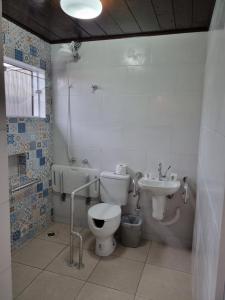 łazienka z toaletą i umywalką w obiekcie Residencial dos Portugas w mieście Boracéia