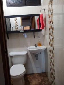 a small bathroom with a toilet and a sink at Cabaña la palma in Copacabana