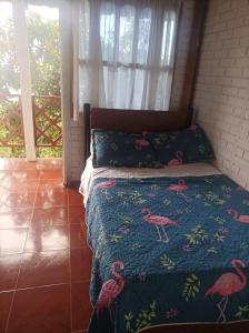 ein Schlafzimmer mit einem Bett mit rosa Flamingos darauf in der Unterkunft Finca Agua Viva in Viotá