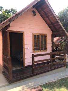 a pink dog house with a bed in it at Chalé da Serra in São João del Rei