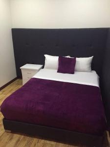 1 dormitorio con 1 cama grande con manta morada en Hotel Casa Morada FC, en Bogotá