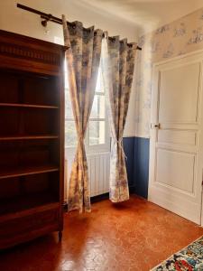 a room with a window with curtains and a door at 1560- Domaine Des Cinq Jardins- A Magical and Authentic Mansion in Fuveau