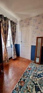 een slaapkamer met blauwe muren en een raam en een deur bij 1560- Domaine Des Cinq Jardins- A Magical and Authentic Mansion in Fuveau