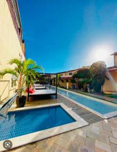 a swimming pool in front of a building at Duplex Solar Água in Pipa