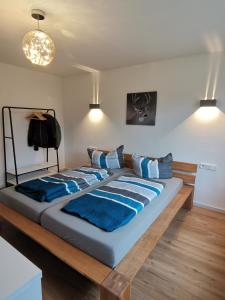 a large bed with blue sheets in a room at Moderne Ferienwohnung Gartenblick in Amtzell