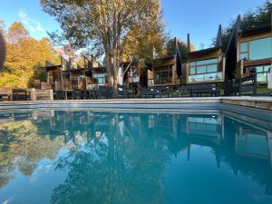 a pool of water with a house in the background at NI-NEWEN Hotel & Lodge in Pucón