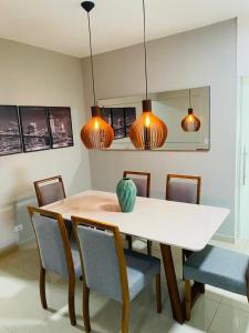 a dining room with a table and chairs and lights at Apartamento próximo da Lucas in Atibaia