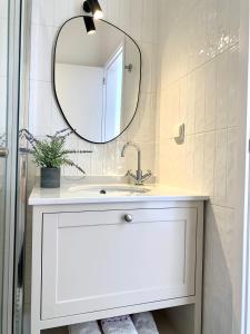 een badkamer met een witte wastafel en een spiegel bij Pátio da Achada View Apartment in Funchal