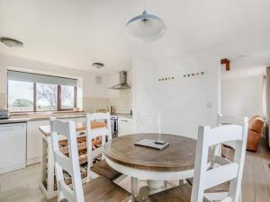 - une cuisine avec une table en bois et des chaises blanches dans l'établissement Beautiful 3 Bedroom Cottage -Cottage 5, à Doncaster