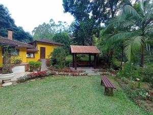 un jardín con banco y cenador en Sitio Recanto da Paz Chalés - casa e chalé para temporada en São Pedro da Serra