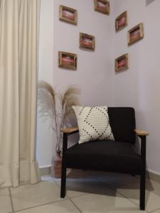 een zwarte stoel in een woonkamer met foto's aan de muur bij Departamento en renta Cabos San lucas in Cabo San Lucas