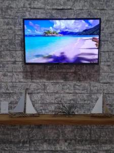 een flatscreen-tv hangend aan een bakstenen muur bij Departamento en renta Cabos San lucas in Cabo San Lucas