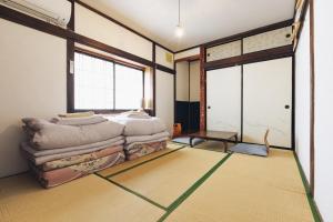 a room with a pile of pillows on the floor at tabi-shiro in Matsumoto