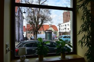 une fenêtre avec vue sur une voiture dans une rue dans l'établissement Apartament w Rynku, à Byczyna