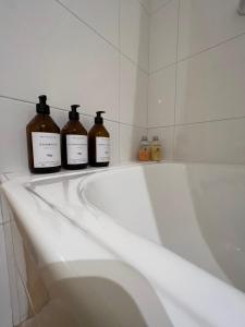 three bottles of wine sitting on top of a bath tub at Departamento INDIGO in Mendoza