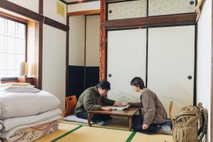 tabi-shiro في ماتسوموتو: يجلس شخصان على طاولة في غرفة النوم