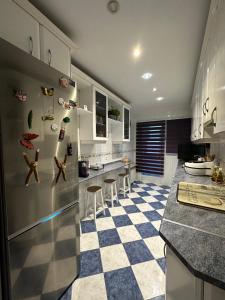 a kitchen with a checkered floor and stainless steel refrigerator at Madera de Olmo in Madrid