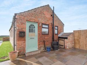 a brick house with a blue door and a grill at Charming 1 Bedroom Cottage in Doncaster