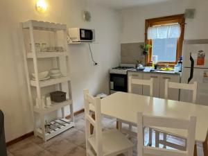 a kitchen with a table and chairs in a kitchen at San Martín de los Andes Depto para 4 Pax in San Martín de los Andes