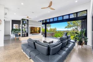 a living room with a large couch and a fireplace at Ohana- Ultimate family escape in Kewarra Beach