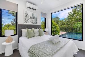 a bedroom with a large bed and a pool at Ohana- Ultimate family escape in Kewarra Beach