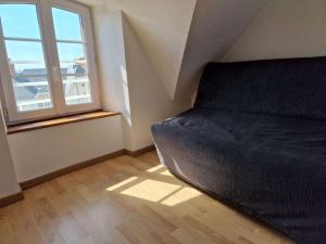 een slaapkamer met een zwart bed en een raam bij Bel appartement cosy et lumineux en duplex in Granville