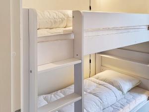 Ce lit superposé blanc se trouve dans un dortoir doté d'un oreiller. dans l'établissement Holiday home Ringkøbing LXXX, à Ringkøbing