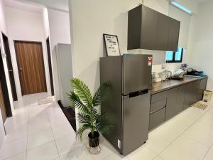 a kitchen with a stainless steel refrigerator and a plant at Imperio Professional Suite by Mama Sue in Alor Setar