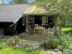 una casa con una mesa y sillas en un patio en Holiday home Kirke Hyllinge X, en Kirke-Hyllinge