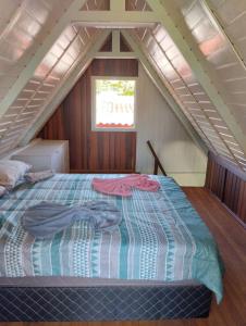 a bedroom with a bed in a attic at Cananéia Chalé 22 in Ilha Comprida +5 photos
