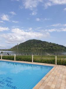 una piscina con una montaña en el fondo en Cananéia Chalé 22 en Ilha Comprida