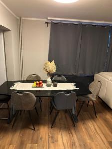 a black table with chairs and a vase of fruit on it at Apartment Hamburg Süd in Hamburg