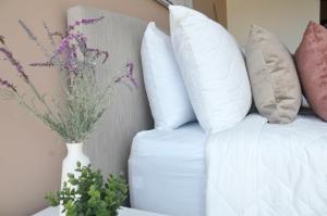 a white couch with pillows and a vase with flowers at Cozy Stays Cayala Apartments near USA Embassy 601 in Guatemala