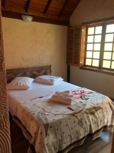 a bedroom with a bed with a blanket on it at Chalé da Serra in São João del Rei +79 photos
