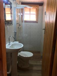 a bathroom with a sink and a toilet and a window at Chalé da Serra in São João del Rei