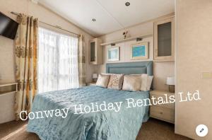 a bedroom with a blue bed and a window at Caravan for Hire Marton Mere Blackpool in Blackpool